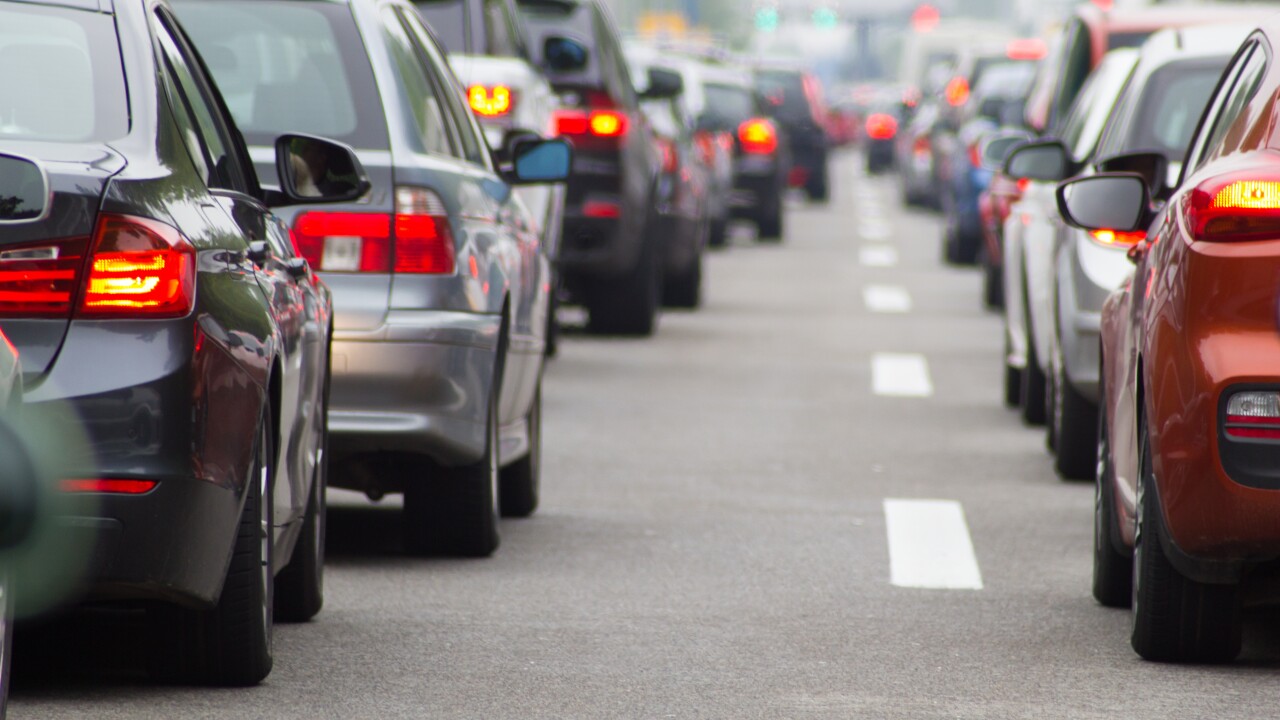 Two lines of cars, in traffic on a road.