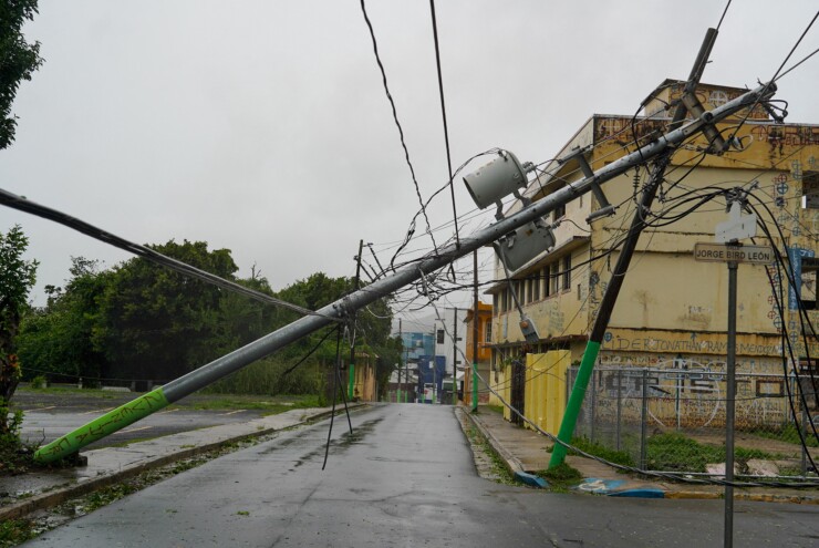 Broken electricity lines above homes damaged after Tropical Storm Ernesto
