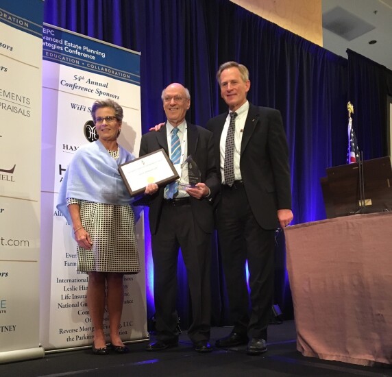 Julie Buschman, chairperson of the AEP designation, and Paul Viren, president of NAEPC, present an award to Edward Mendlowitz