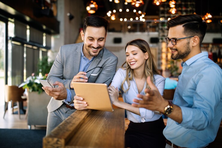 Three employees looking at tablet