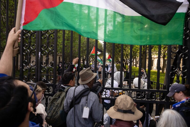 Pro-Palestinian demonstrators at Columbia University; Palestinian flag waves in front of the front gates.