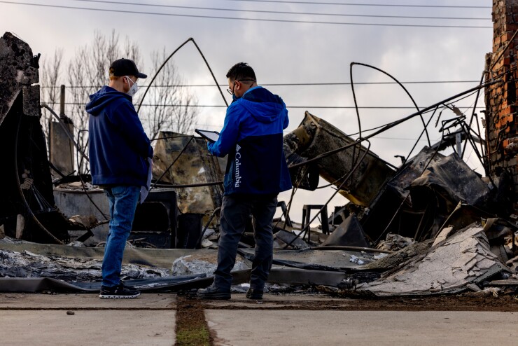 A resident whose house was destroyed speaks with a FEMA worker after the Eaton Fire in Pasadena, California, Jan. 17, 2025.