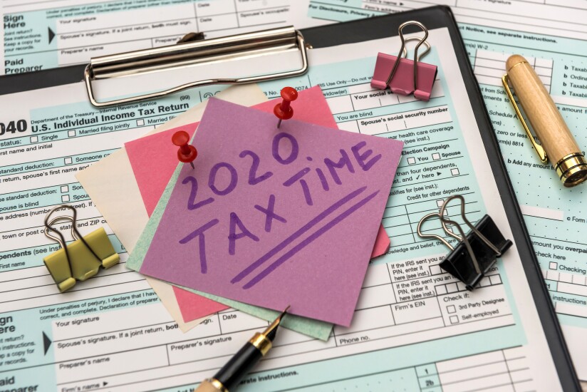 2020 Tax Company. Colorful stickers with reminder at 1040 tax form close up