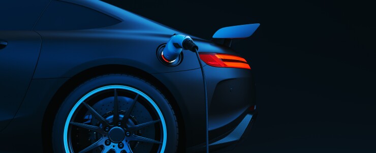 A silhouette of an electric vehicle charging