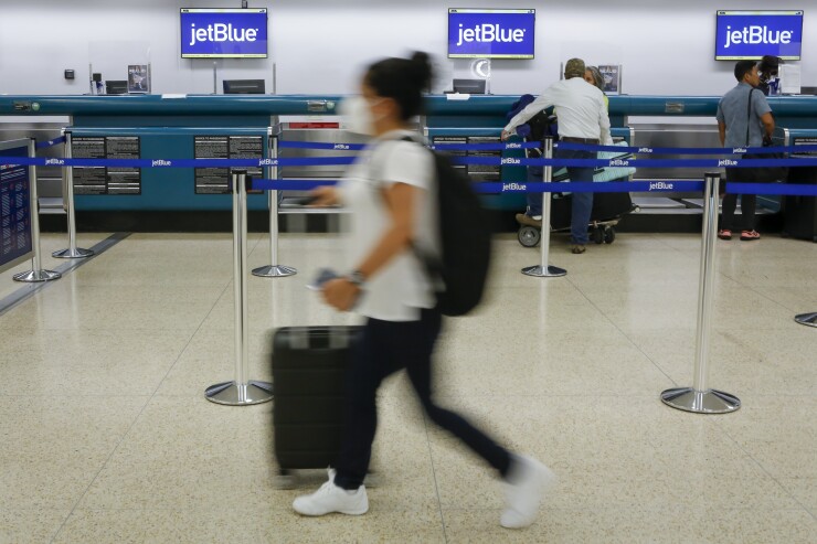 Travelers at the JetBlue counter at Miami International Airport.