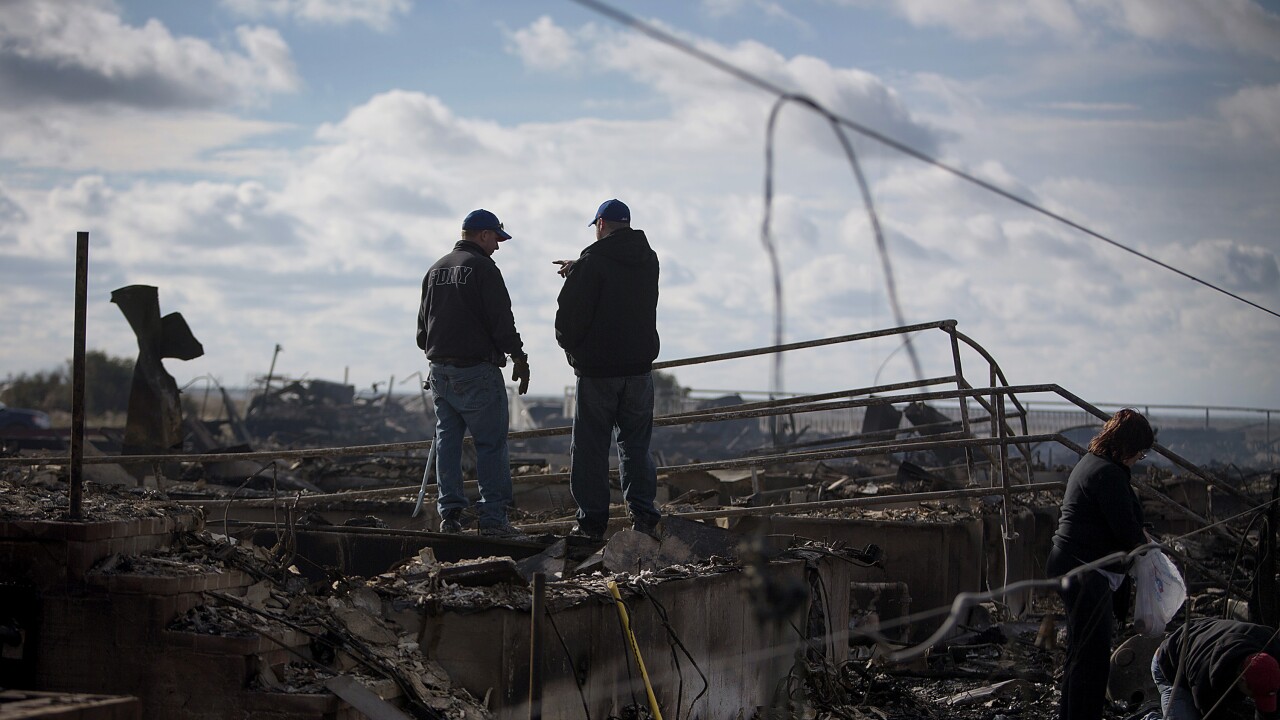 Residents look over the damage to their home in the Breezy Point neighborhood of the Queens borough of New York, U.S., on Wednesday, Oct. 31, 2012.