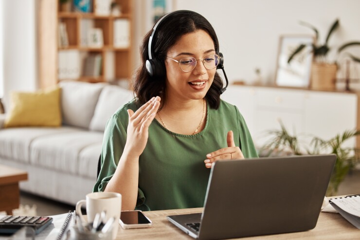 A woman speaking with colleague on video chat.