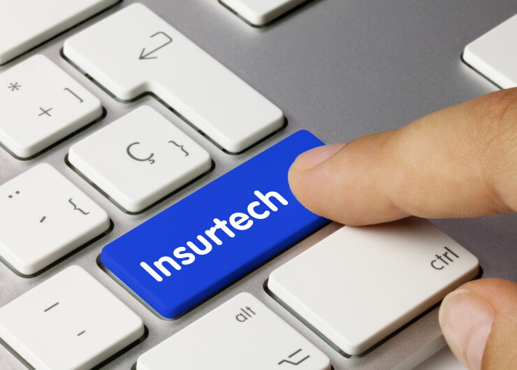 A person pressing an insurtech key on a keyboard.