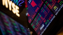 A monitor displays stock market information on the floor of the New York Stock Exchange.