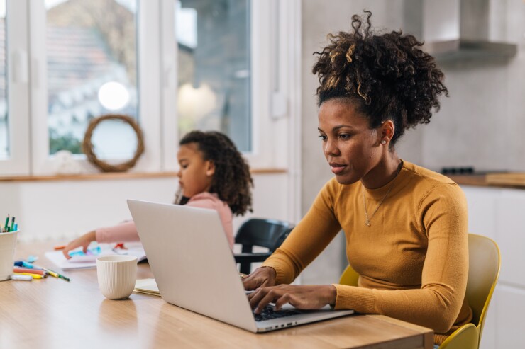 Black mom working from home with daughter