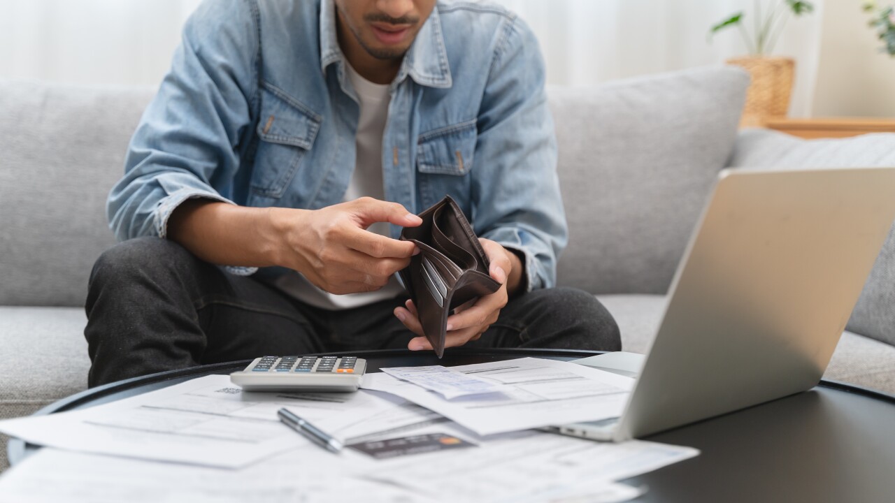 Man looking at empty wallet, money help