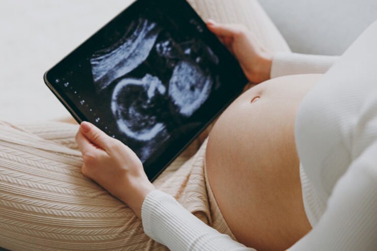 Pregnant woman looking at sonogram image on ipad