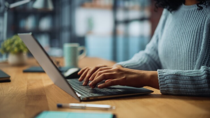 A person using a laptop on a desk