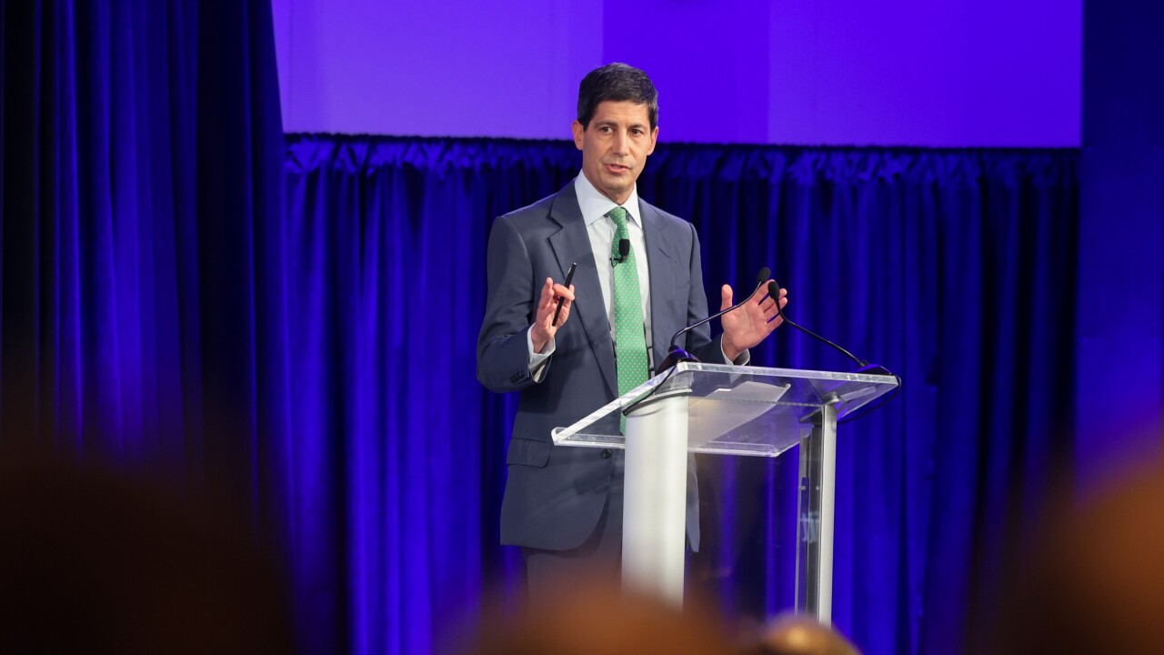 Kevin Warsh speaks at a lucite podium