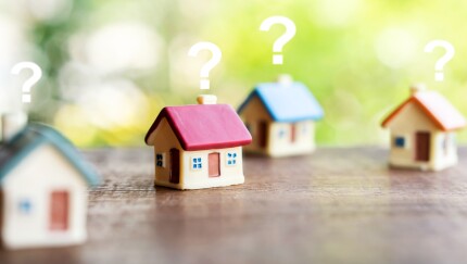 miniature house model with question mark, looking for new home, buy or rent real estate concept