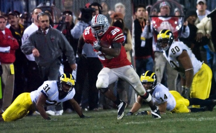 Ohio State tailback Antonio Pittman (25) avoids Michigan tacklers Brandent Englemon (37), Trent Morgan (14) and Alan Branch (80) as he runs down the sidelines in the fourth quarter in Columbus, Ohio.