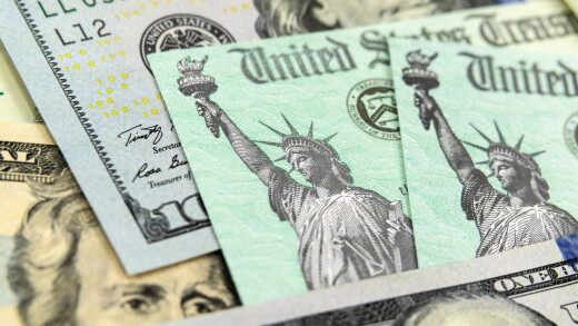 Macro view of the Statue of Liberty on a United States Treasury Checks with currency in background