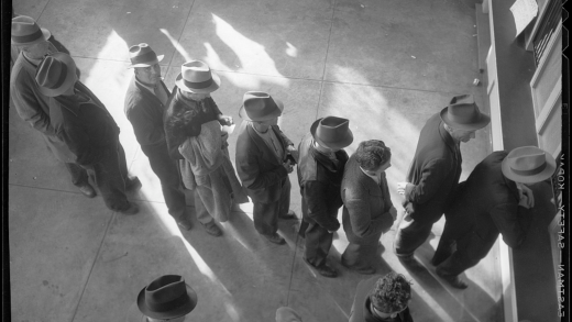 A photograph by Dorothea Lange of men filing for unemployment benefits in San Francisco in 1938.