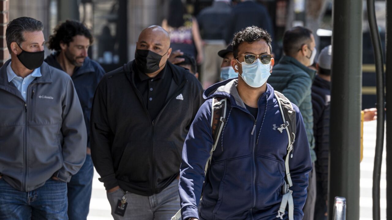 People wearing protective masks walk on Columbus Avenue in San Francisco, California, U.S., on Thursday, May 6, 2021. San Francisco advanced into the least restrictive tier of California’s color-coded reopening system Tuesday, allowing most businesses to expand capacity, bars to start serving indoors and large gatherings to resume inside and outside. Photographer: David Paul Morris/Bloomberg