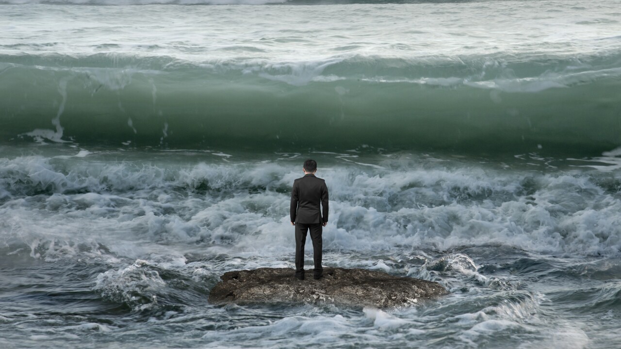 Businessman facing oncoming waves