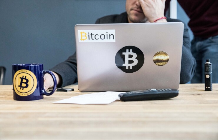 An employee uses a laptop computer branded with bitcoin logos inside the offices of La Maison du Bitcoin bank in Paris.