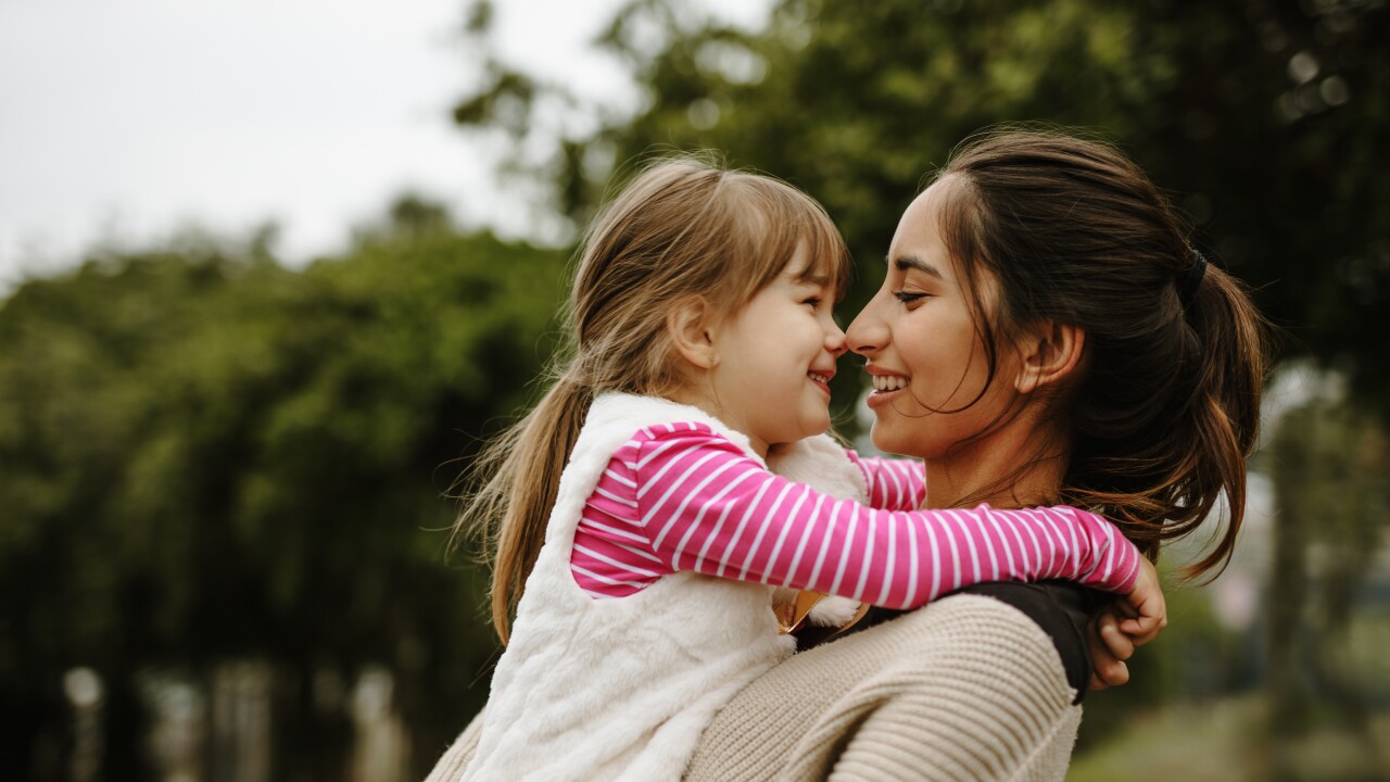 Mom holding daughter and smiling