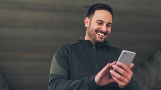 Man smiling holding cell phone