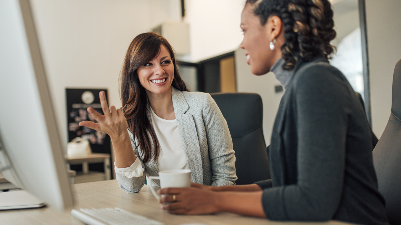 Two women talking to each other at the office
