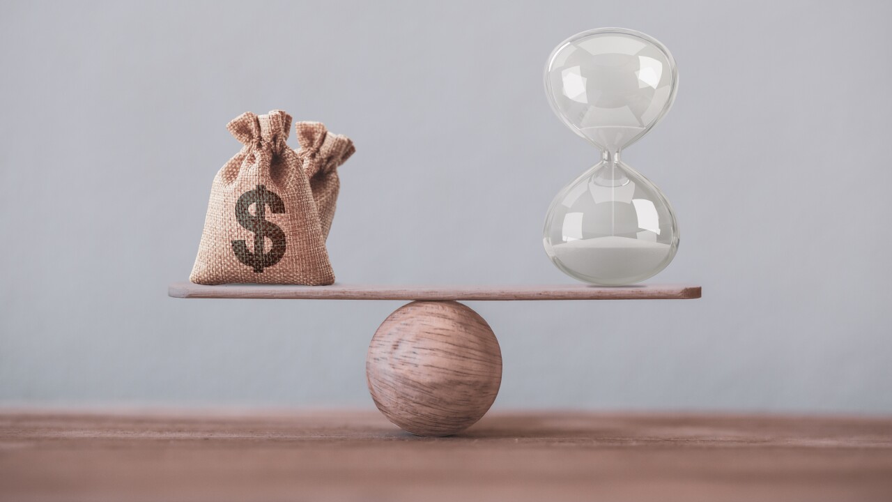 Financial concept : Write sand clock or hourglass symbol and dollar bagson a balance scale in equal position.Time value of money, asset growth over time, investment in long-term equity for more money