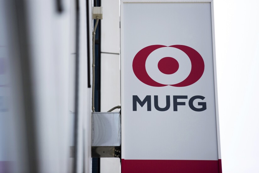 The logo of Mitsubishi UFJ Financial Group (MUFG) is displayed on a sign outside a Bank of Tokyo-Mitsubishi branch in Tokyo.