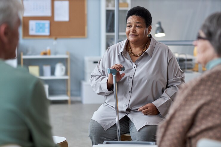 A health professional talks to two people.