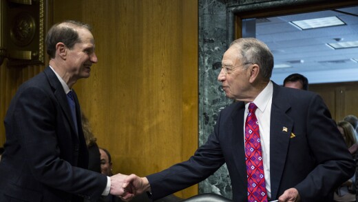 Senate Finance Committee ranking member Ron Wyden, D-Ore. (left), shakes hands with committee chairman Chuck Grassley, R-Iowa.