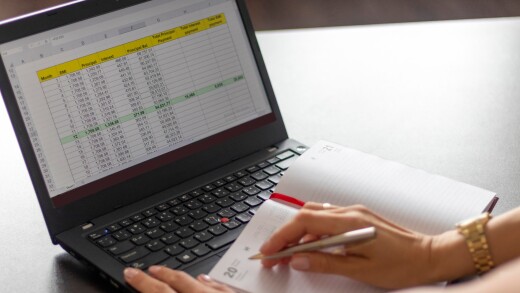 Shot of a woman working on the laptop showing an excel sheet on the screen with bank loan amortization table. Finance