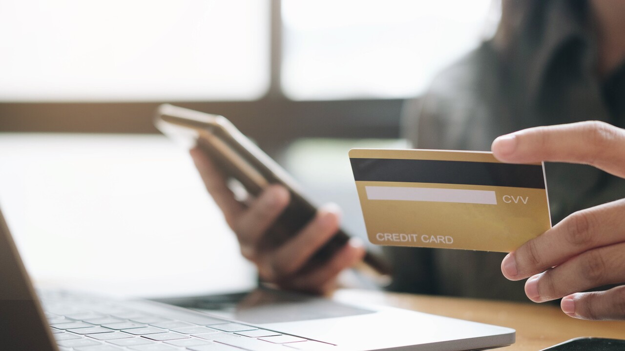 Hands holding credit card and using laptop. Online shopping.