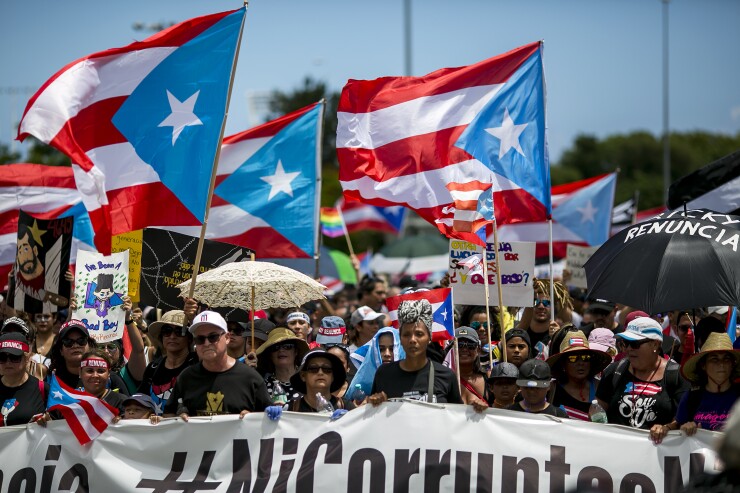 Demonstrators wave Puerto Rican flags during a protest in San Juan, Puerto Rico, on July 22.