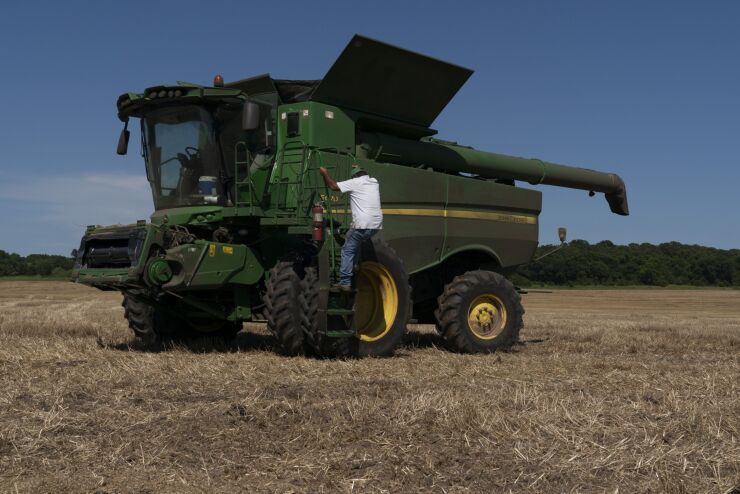 A farmer climbs into a combine harvester in Oklahoma.