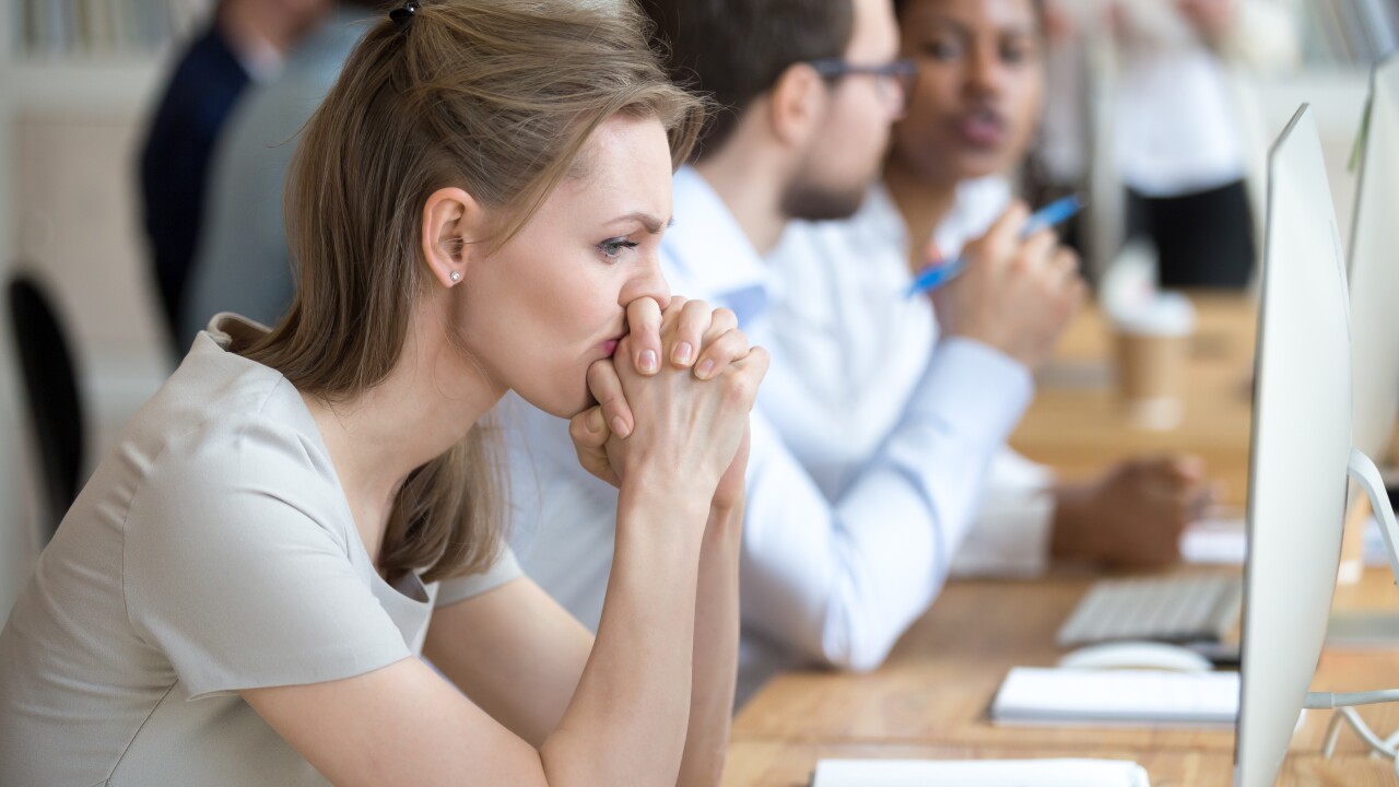 Uncertain or preoccupied female employee with hands clasped