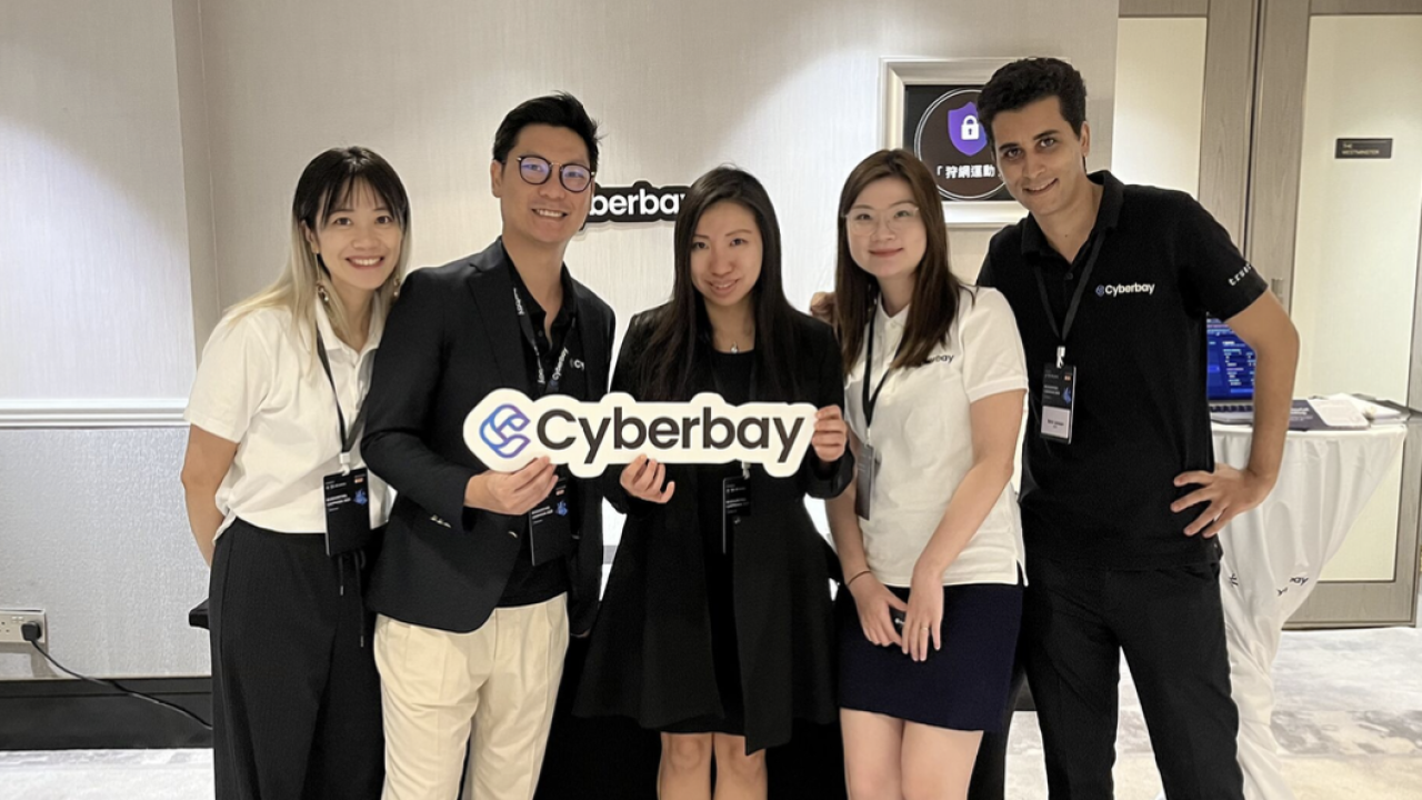 A group of people standing together holding a sign that reads Cyb
