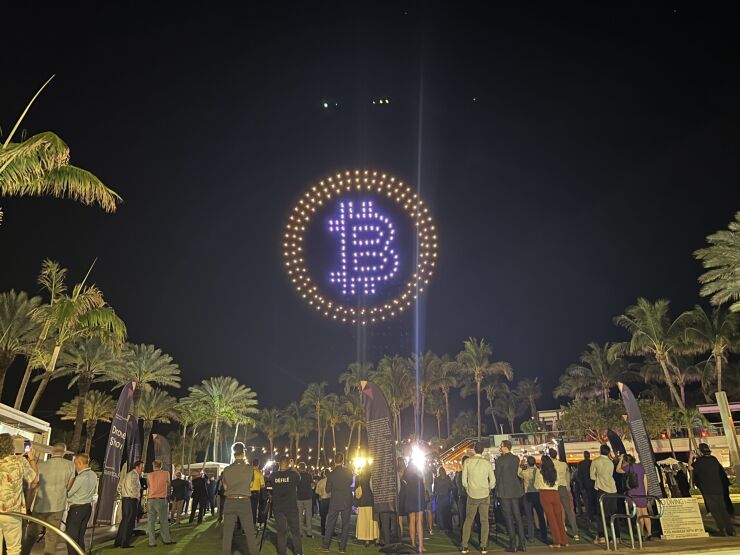 Bitcoin symbol projected into night sky in Miami during Exchange conference in 2024