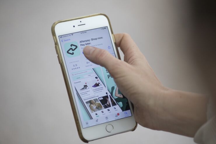 The Afterpay application download page arranged on a smartphone in Sydney, Australia, on Tuesday, Aug. 3, 2021. Square Inc., the digital-payments platform led by Twitter Inc. founder Jack Dorsey, agreed to buy Australian buy-now, pay-later company Afterpay Ltd. for $29 billion in its largest-ever acquisition. Photographer: Brent Lewin/Bloomberg