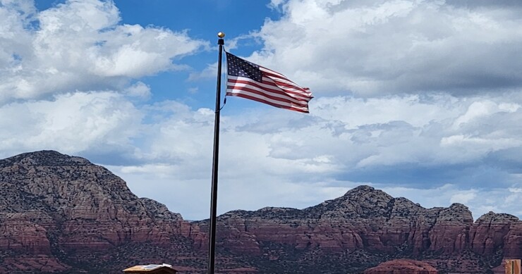 American flag flying over the mountains in Sedona, AZ.