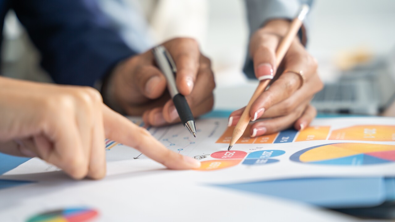 Hands pointing to charts in a strategy meeting