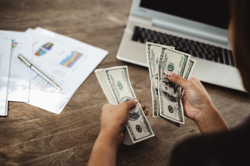 Woman's hands counting out a stack of money