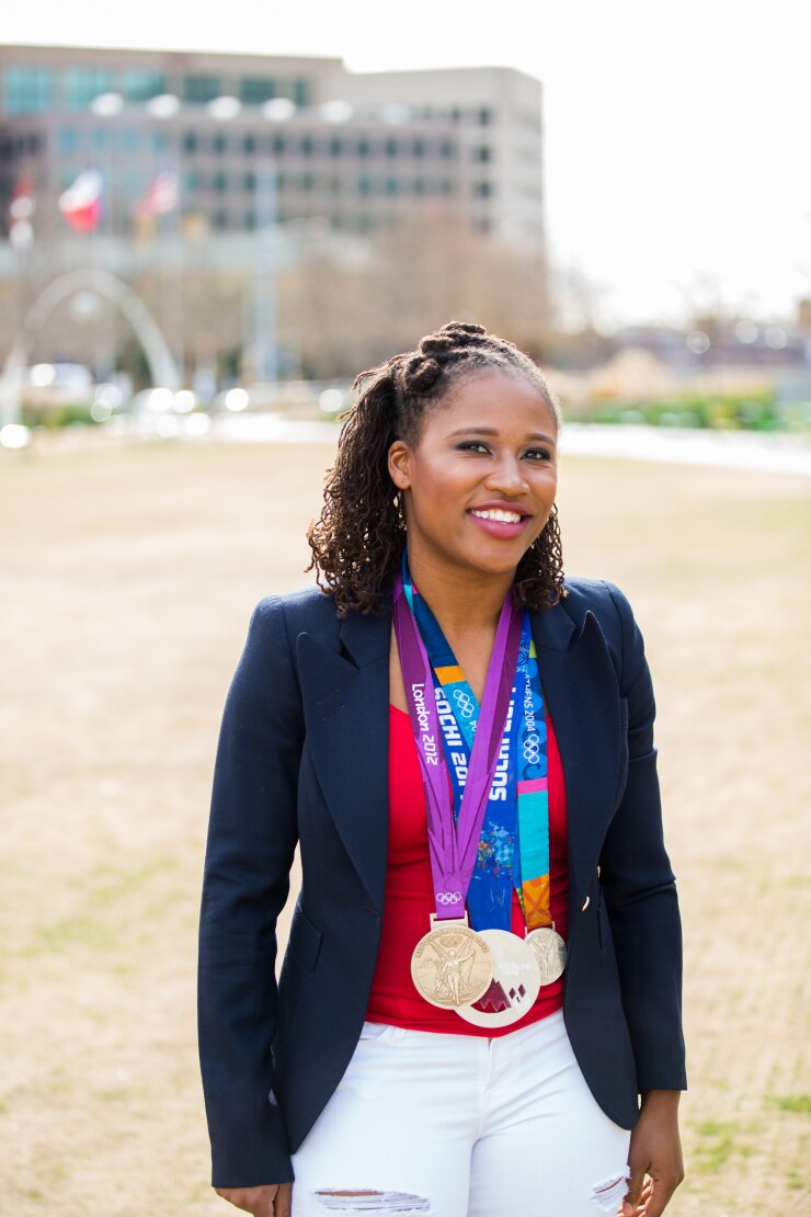 Financial advisor Lauryn Williams stands with her Olympic medals from track and bobsled.