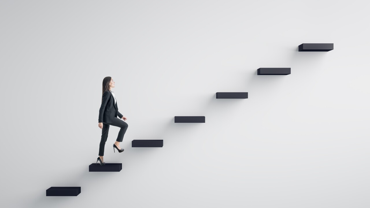 A woman in a business suit climbs up stair steps on the path to career success