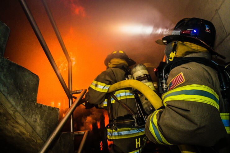 Firefighters training inside a burning building.