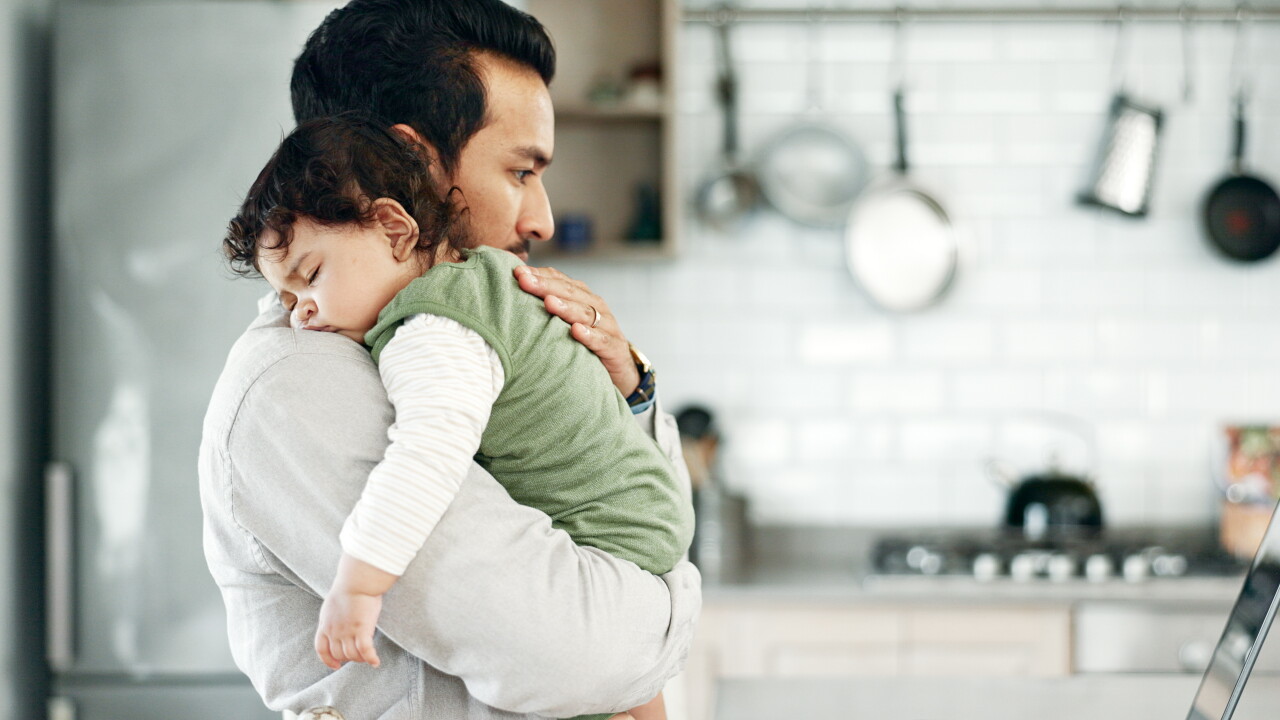 Man, baby or laptop in kitchen for sleeping, care or multitask with remote work. Father, tired child or reading tech for research, childcare tips or infant burping tutorial in home on paternity leave.