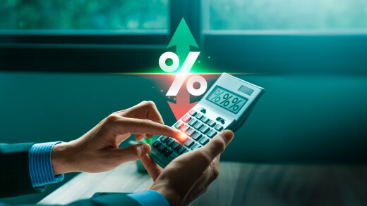 A business professional analyzes fluctuating interest rates using a calculator.