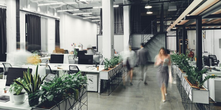 An open concept office with blurred people walking.