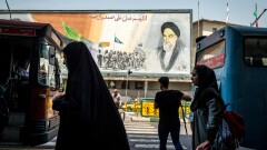 Pedestrians pass in front of a political mural in Tehran depicting Ruhollah Khomeini, founder of the Islamic republic of Iran.